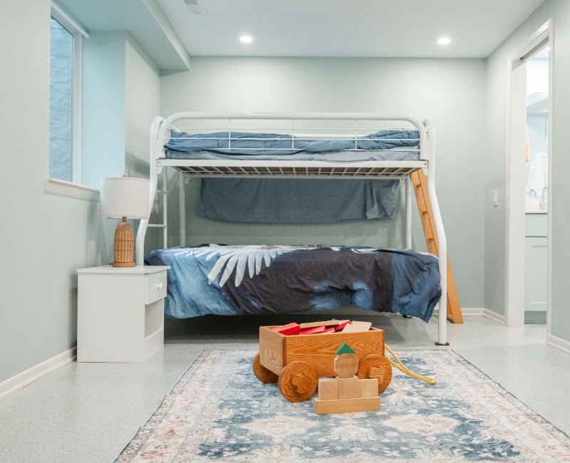 A basement remodel in Madison, WI that transformed an unfinished basement into a rec room, complete with a private full bath. The layout gives the kids a place that’s entirely their own: room to run around, play with toys, and sleep. 