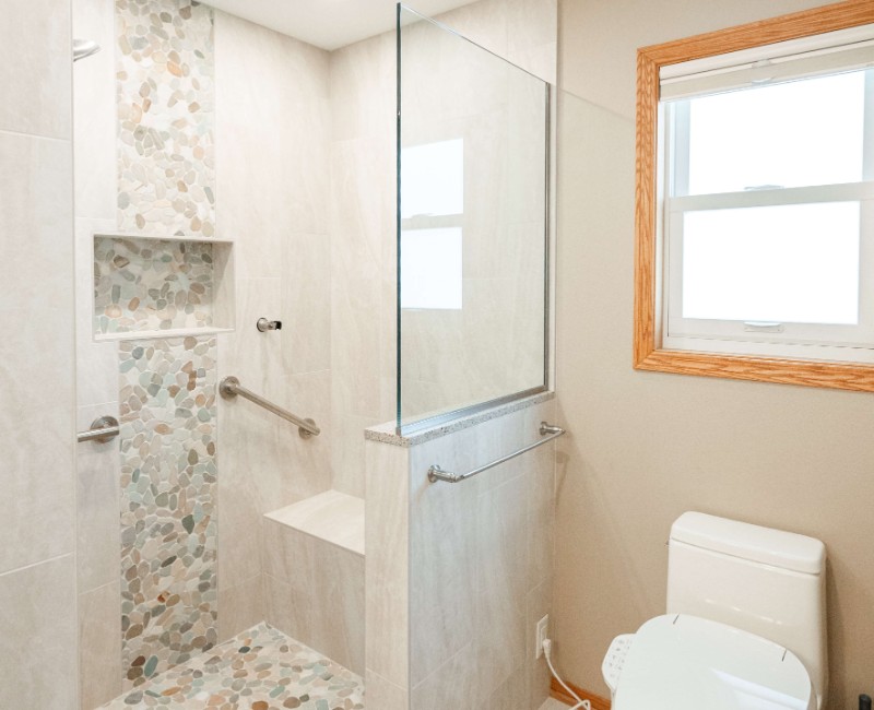 This bathroom renovation in a home on Madison's west side was part of a complete kitchen and bath remodel. In the primary bathroom, we removed the original tub and replaced it with a custom walk-in shower. The shower is hassle-free and easy to clean with no door or curtain. 