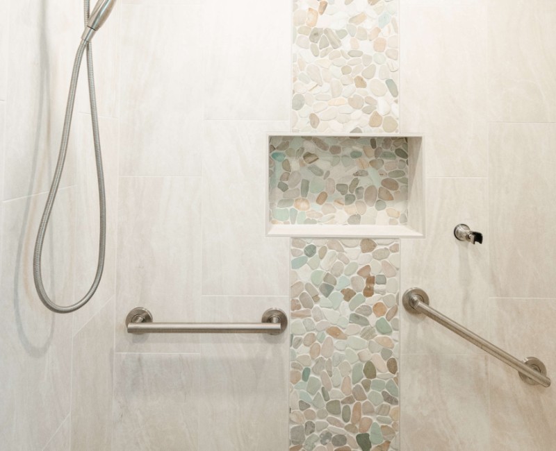 This bathroom renovation in a home on Madison's west side was part of a complete kitchen and bath remodel. In the primary bathroom, we removed the original tub and replaced it with a custom walk-in shower. The shower is hassle-free and easy to clean with no door or curtain. 