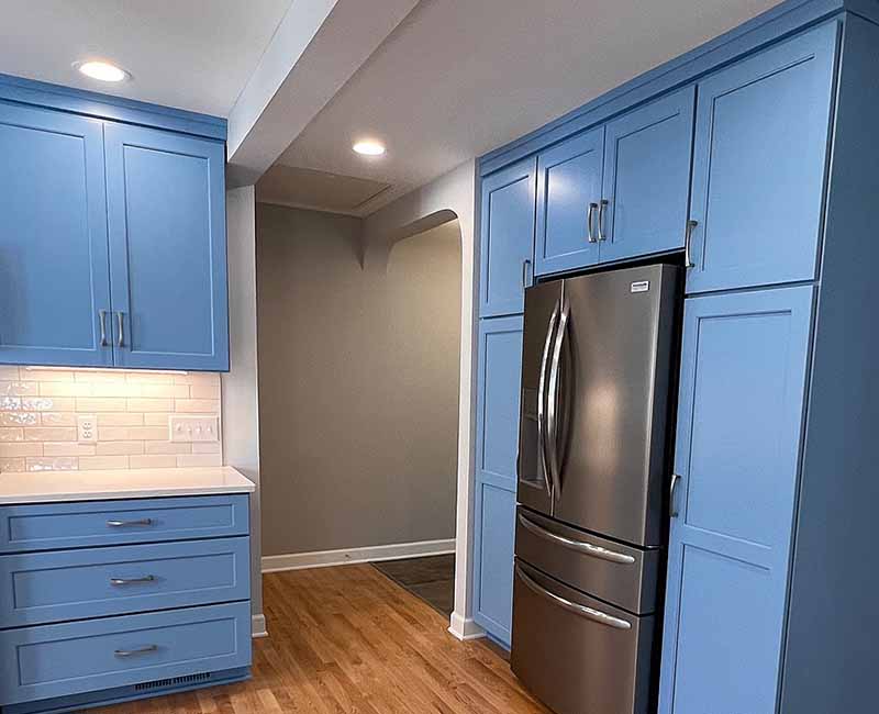 This kitchen in Madison, WI was remodeled to provide ample space for the family to gather and cook together. It features blue cabinetry and white and gray subway tiles.