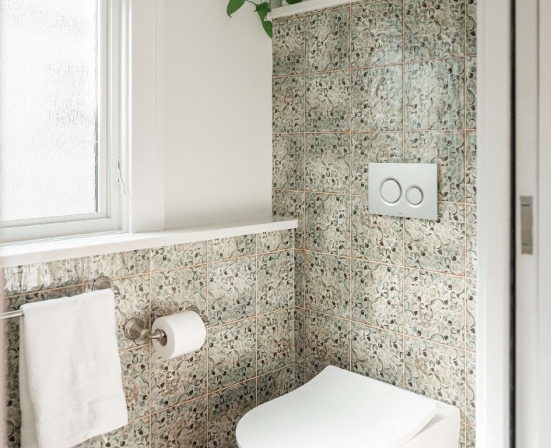 What began as a cold, drafty enclosed porch is now one of the homeowners’ favorite rooms. A bright, energy-efficient sunroom with a beautifully integrated first-floor bathroom. 