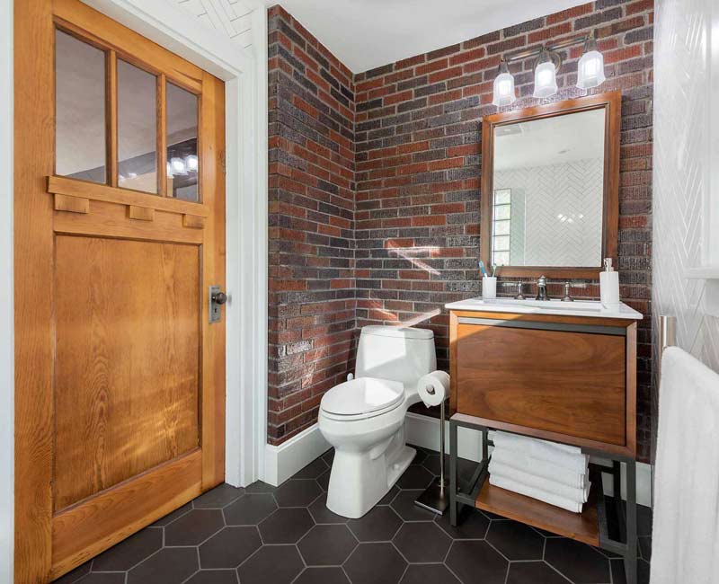 For this 100-year-old farmhouse in Mt. Horeb, WI, we remodeled the primary bathroom, kitchen, mudroom, and entryway. We also updated the pantry to include a built-in sliding ladder and restored the front porch.