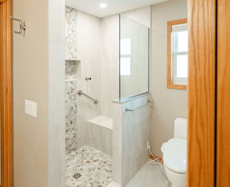 This bathroom renovation in a home on Madison's west side was part of a complete kitchen and bath remodel. In the primary bathroom, we removed the original tub and replaced it with a custom walk-in shower. The shower is hassle-free and easy to clean with no door or curtain. 