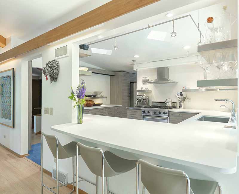 We remodeled the kitchen in this mid-century modern home in Madison, WI to showcase the homeowner's love for food, art, and architecture. It features a Viking Professional freestanding range oven and a Zephyr range hood so the homeowner can bake and cook as well at their home as at their restaurant.