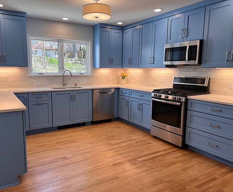 This kitchen in Madison, WI was remodeled to provide ample space for the family to gather and cook together. It features blue cabinetry and white and gray subway tiles.
